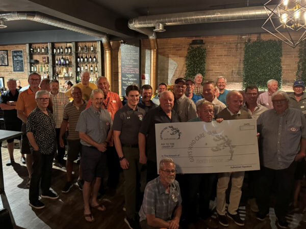 Guys Who Care group holding a cheque at the Fall meeting